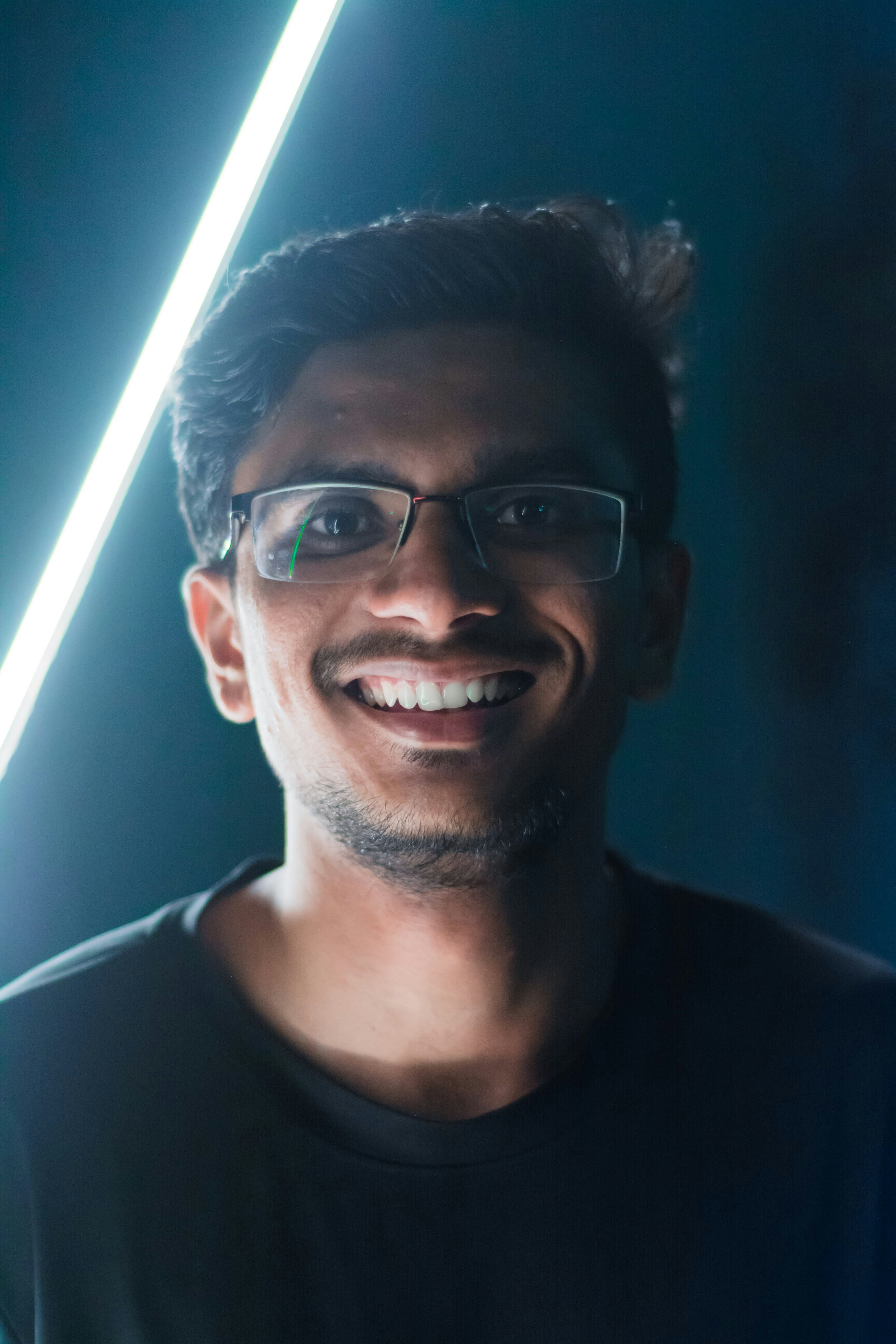 Portrait of Nico Ambrose smiling, wearing glasses